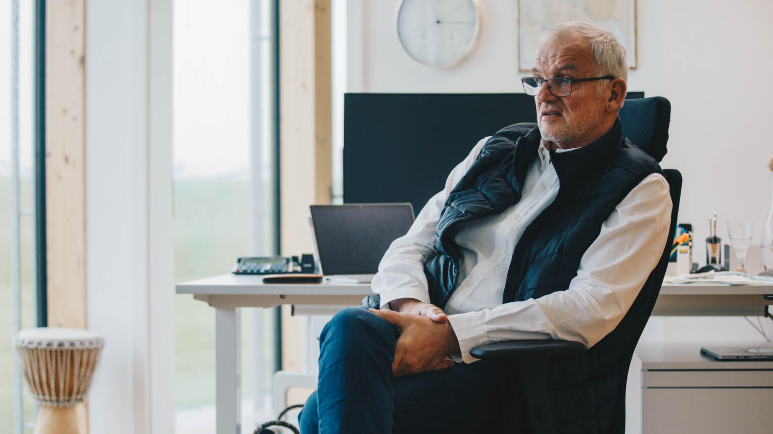 Geschäftsführer Dirk Ketelsen sitzt auf einem Schreibtischstuhl, im Hintergrund ein heller Büroraum mit einem Schreibtisch und einer Trommel vor dem Fenster.