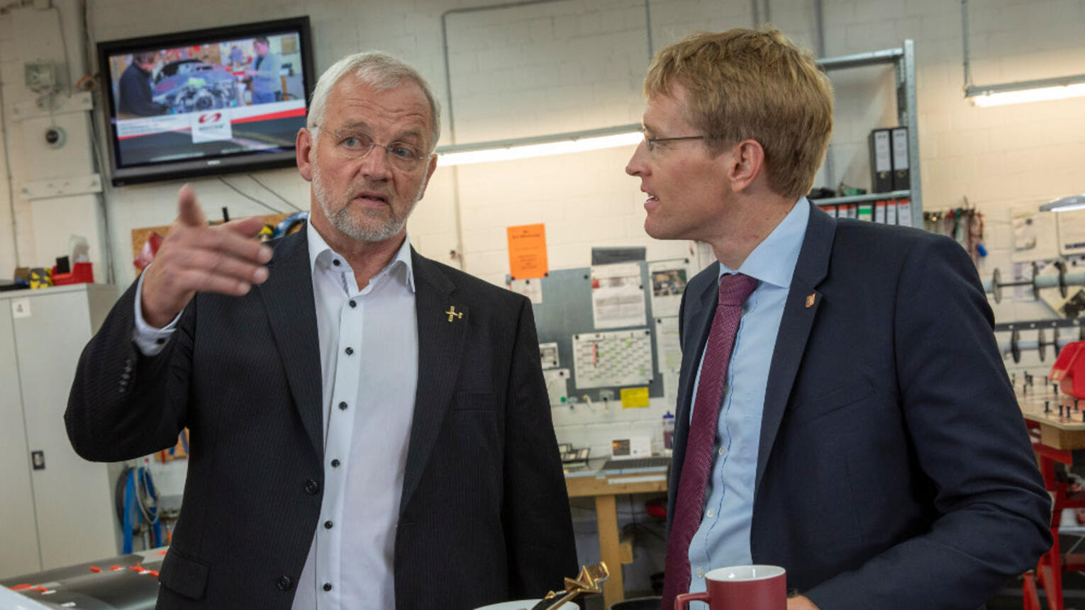 Der Ministerpräsident und Dirk Ketelsen im Gespräch in einer Halle.