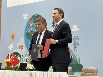 Die Energieminister von Deutschland und der Türkei halten Mappen mit Vereinbarungen zur Energiepolitik hoch.