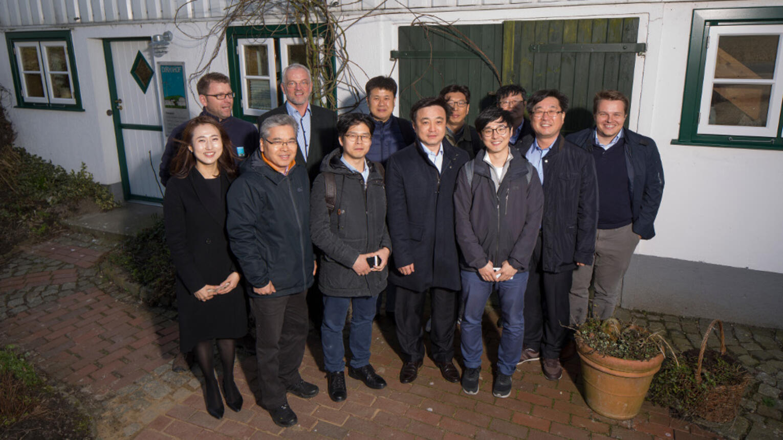 Koreanische Besucher posieren für ein Gruppenfoto vor dem Eingang des Dirkshofs.