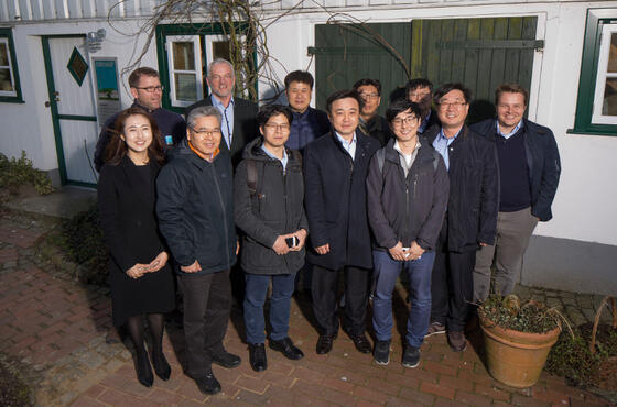 Koreanische Besucher posieren für ein Gruppenfoto vor dem Eingang des Dirkshofs.